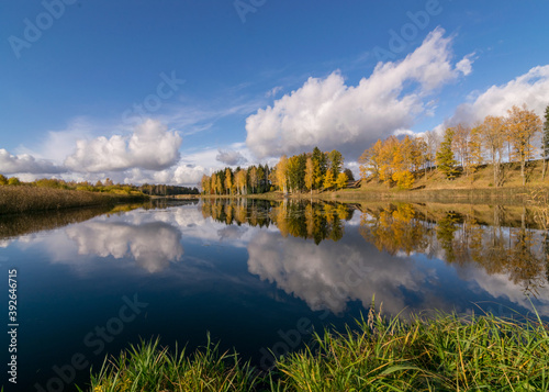 colorful autumn panoramas with yellow trees by the lake, beautiful and colorful reflections in the calm lake water, golden autumn