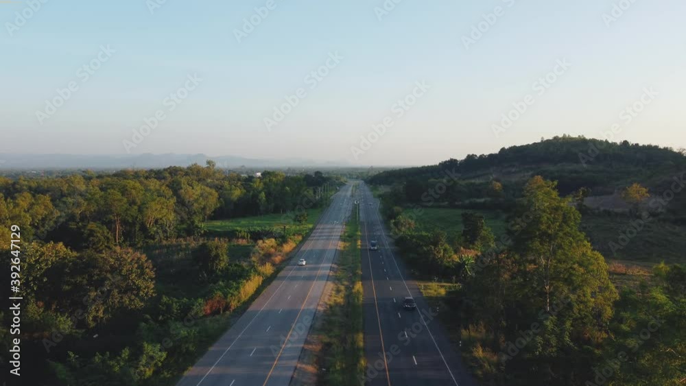 Aerial view of drone flying shot traffic over asphalt highway road with car driving and nature green trees in the evening Aerial view of drone flying shot traffic over asphalt highway road with car driving and nature green trees in the evening