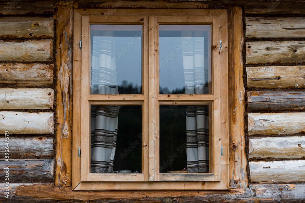 Traditional log house insulated with moss, pine wood  window in the forests.