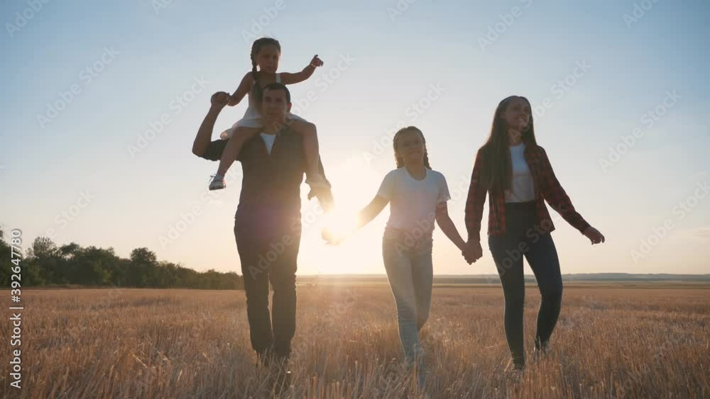 Cute happy family walks park in evening at sunset.Parents, children,dads,mother,daughter walk holding hands across field.Young happy family enjoy socializing together in park.Children, loving parents. Cute happy family walks park in evening at sunset.Parents, children,dads,mother,daughter walk holding hands across field.Young happy family enjoy socializing together in park.Children, loving parents.