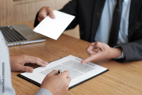 Business man sending resignation letter to boss and Holding Stuff Resign Depress or carrying cardboard box by desk in office.