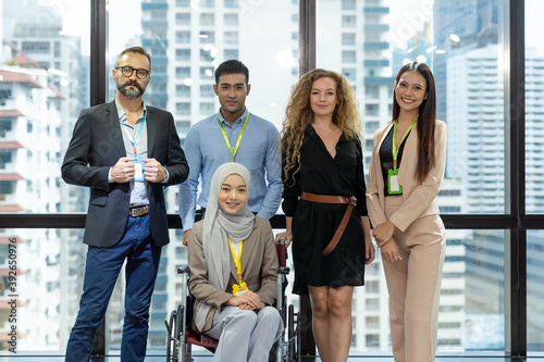 Smiling group of diverse corporate colleagues in the modern office. Group of professional team business people standing together in the office