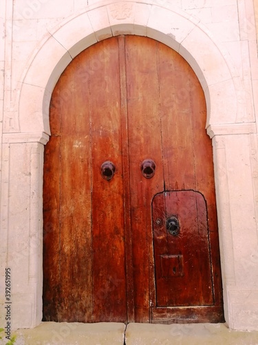 Traditional wooden brown aged Tunisian door in Hammamet medina. Hammamet, Tunisia. 06/16/2019. 