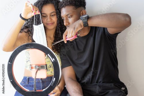 Close up of a influencer couple deniers against coronavirus fraud..Focus of scissors while cutting a surgical mask, concept of protesting against coronavirus scams. photo