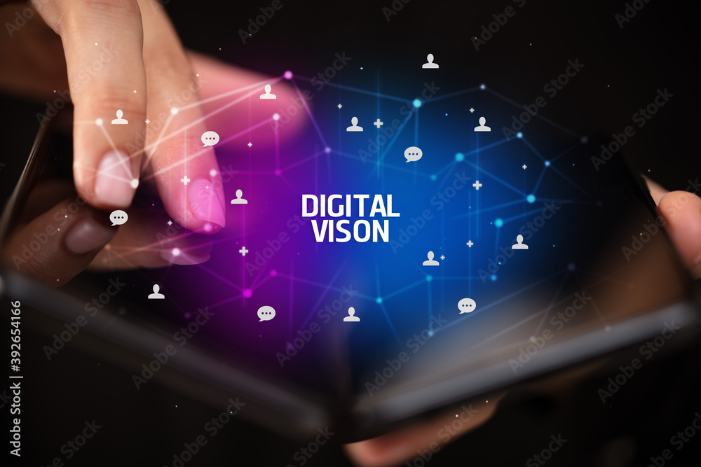 Businessman holding a foldable smartphone with DIGITAL VISON inscription, new technology concept Businessman holding a foldable smartphone with DIGITAL VISON inscription, new technology concept
