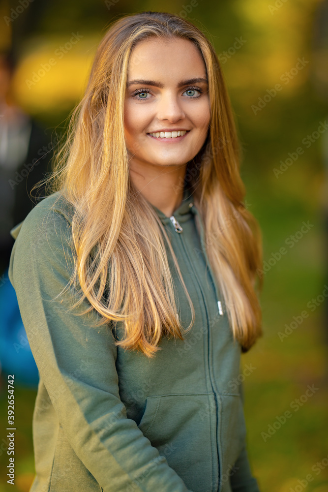 Confident young blond woman standing at park Confident young blond woman standing at park