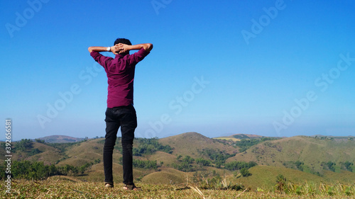 A Young man wondering at the view of vagamon hills , Kerala, India