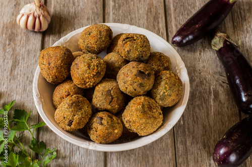 Meatless eggplant meatballs on wooden background.