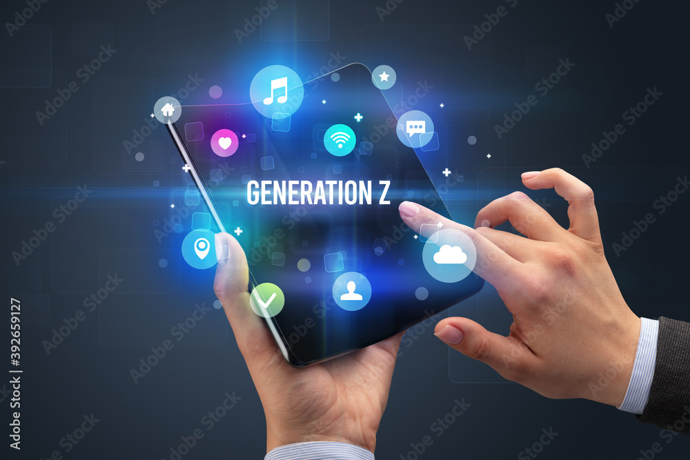 Businessman holding a foldable smartphone with GENERATION Z inscription, social media concept Businessman holding a foldable smartphone with GENERATION Z inscription, social media concept