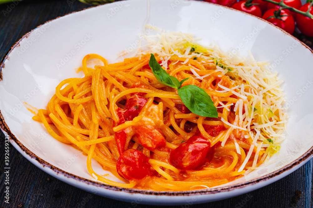 Traditional Italian pasta with tomato, parmesan cheese and basil on white plate. Traditional Italian pasta with tomato, parmesan cheese and basil on white plate.