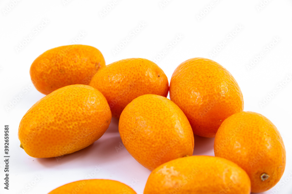 Lots of little kumquats or fortunella on white isolated background macro Lots of little kumquats or fortunella on white isolated background macro