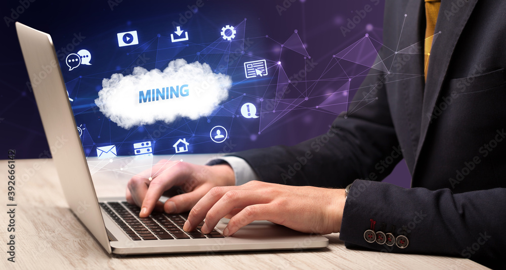 Businessman working on laptop with MINING inscription, modern technology concept Businessman working on laptop with MINING inscription, modern technology concept