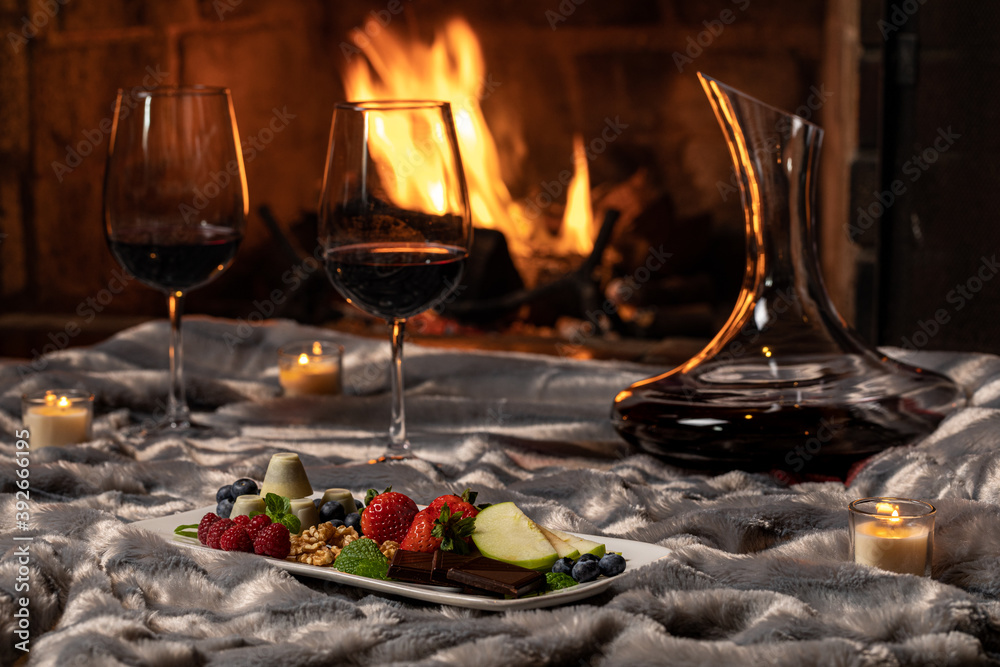 Red wine at fireplace with strawberries and chocolate