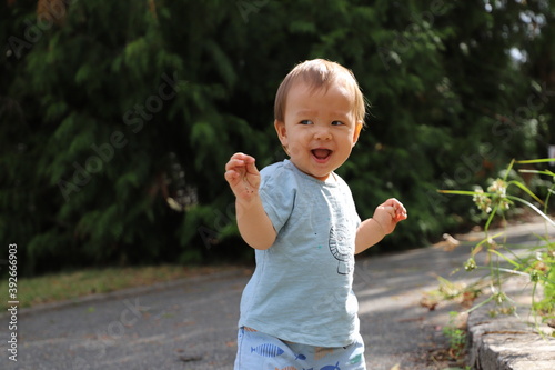 Enfant garçons un an debout sourie dans parc