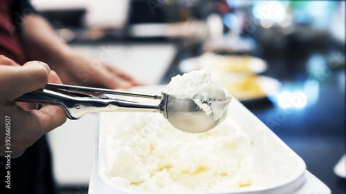 Woman picks ice cream with a round spoon