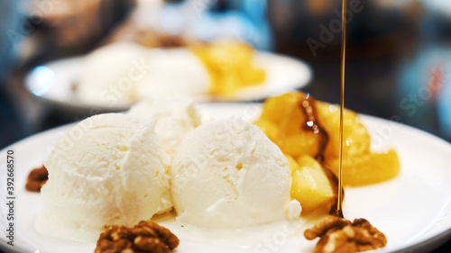 Vanilla icecream with fried orange and apple poured with delicious narsharab sauce. Walnut. Close up photo