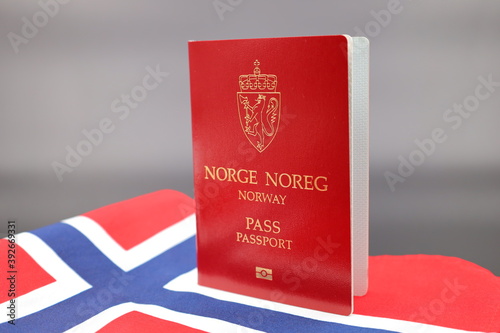 Drammen, Norway - November 20 2020: Norwegian passport on norway flag with gradient background. Passport of Kingdom of Norway.