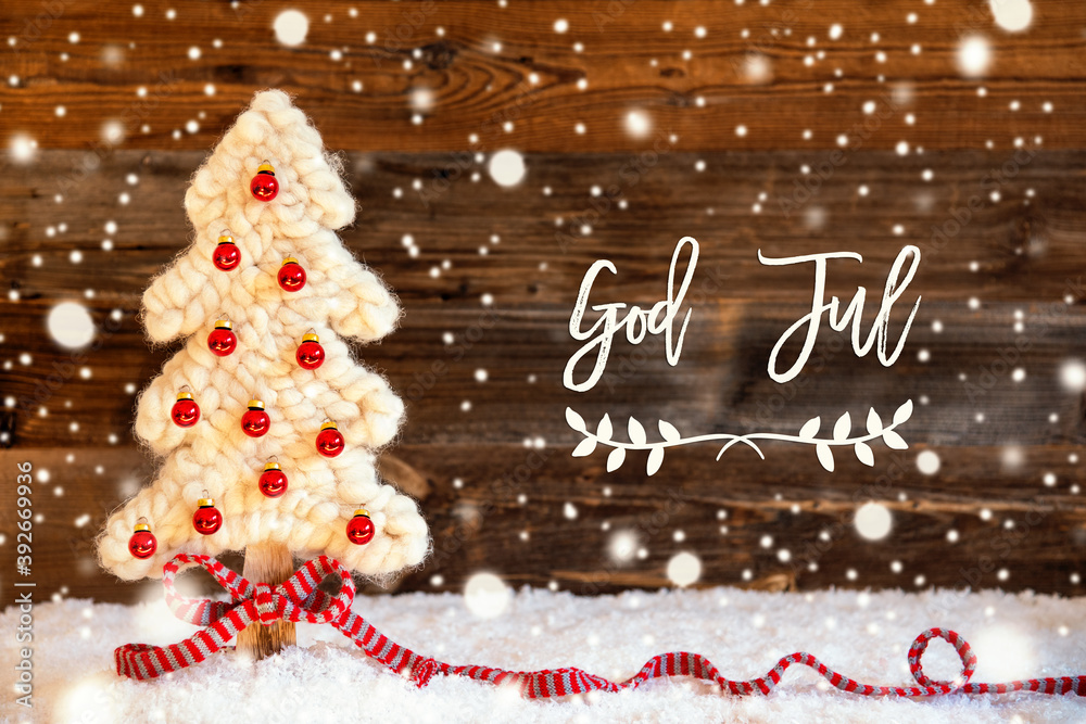 © Nelos - Swedish Calligraphy God Jul Means Merry Christmas. White Fabric Christmas Tree With Red Christmas Ball Ornament. Brown Rustic Wooden Background With Snow And Snowflakes © Nelos - Swedish Calligraphy God Jul Means Merry Christmas. White Fabric Christmas Tree With Red Christmas Ball Ornament. Brown Rustic Wooden Background With Snow And Snowflakes