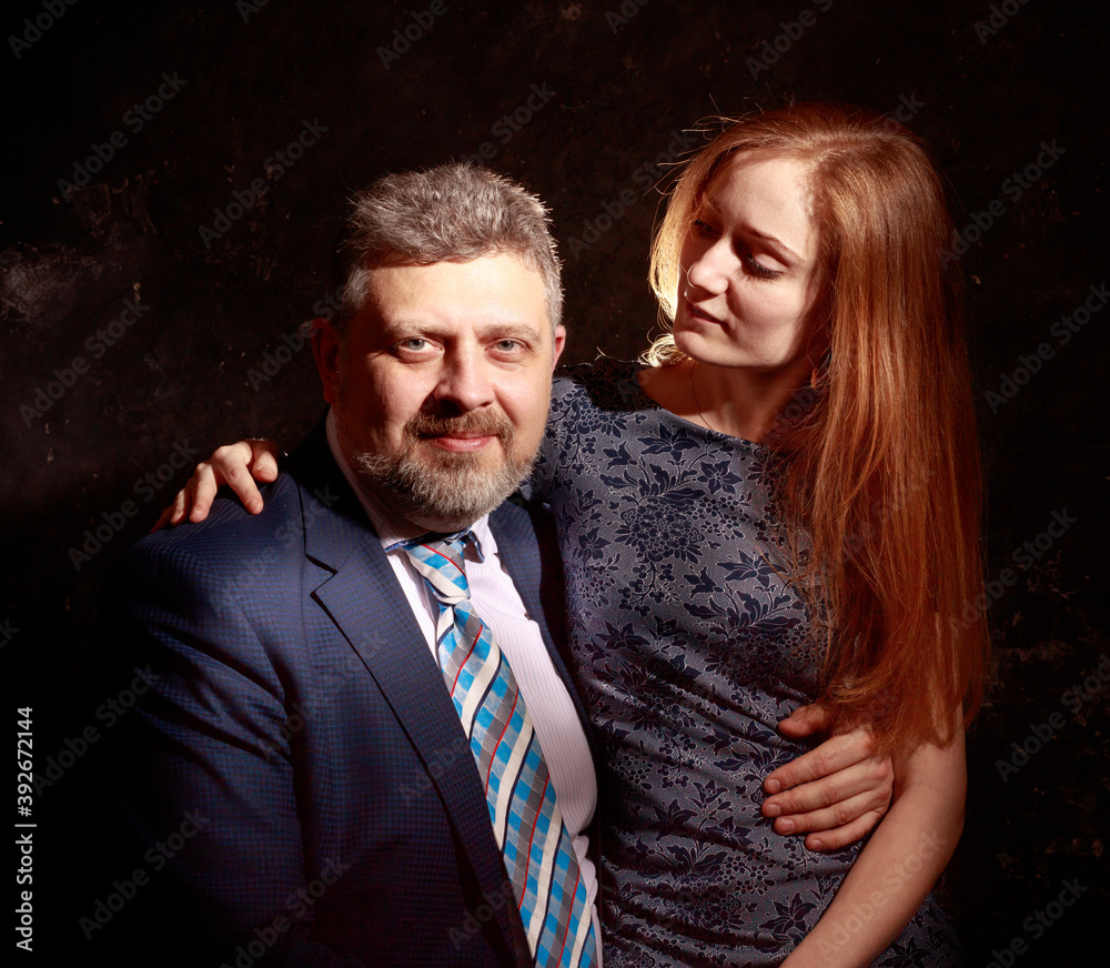 Bearded man and young woman, happy couple studio portrait