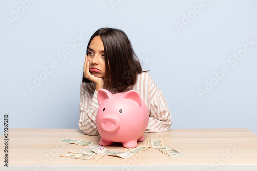 hispanic woman feeling bored, frustrated and sleepy after a tiresome, dull and tedious task, holding face with hand