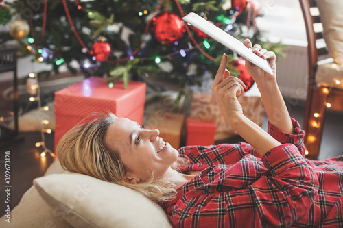 Woman with tablet near christmas tree