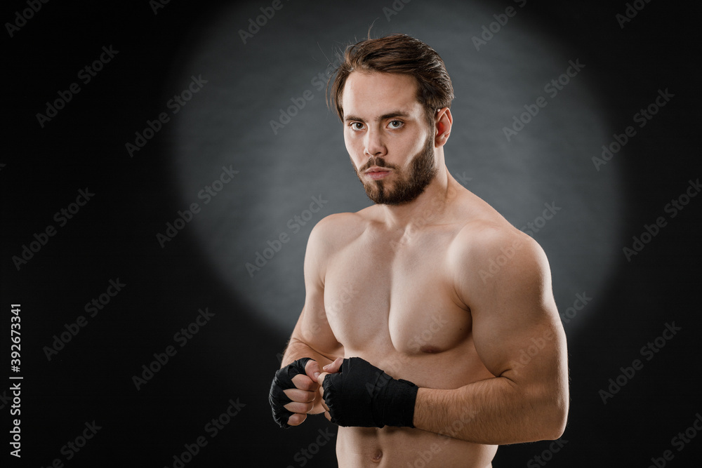 Portrait of a boxer with bandages on his hands. Fists of a fighter before a fight or training in the gym. The concept of sport