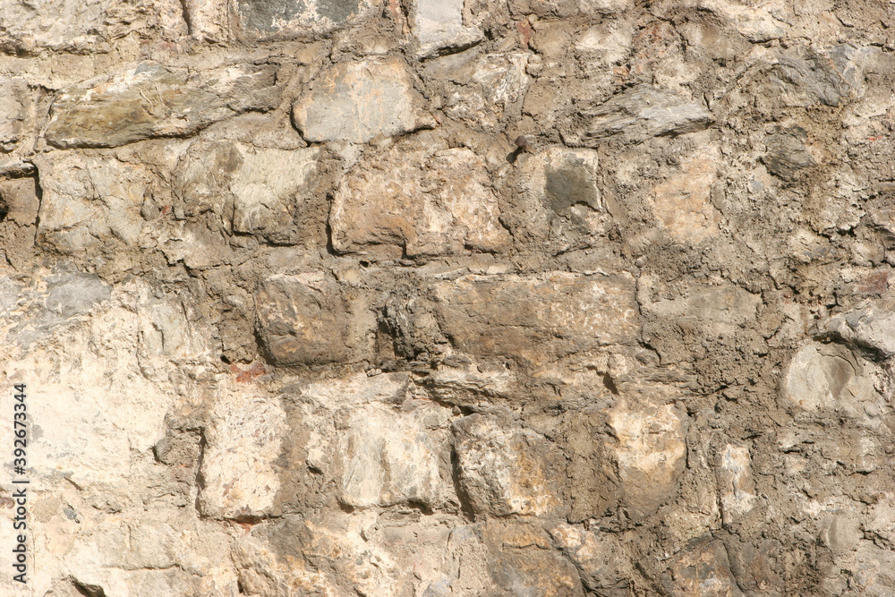 Old beige stone wall texture background close up