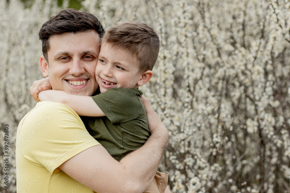 Image of happy man holding his son while having fun