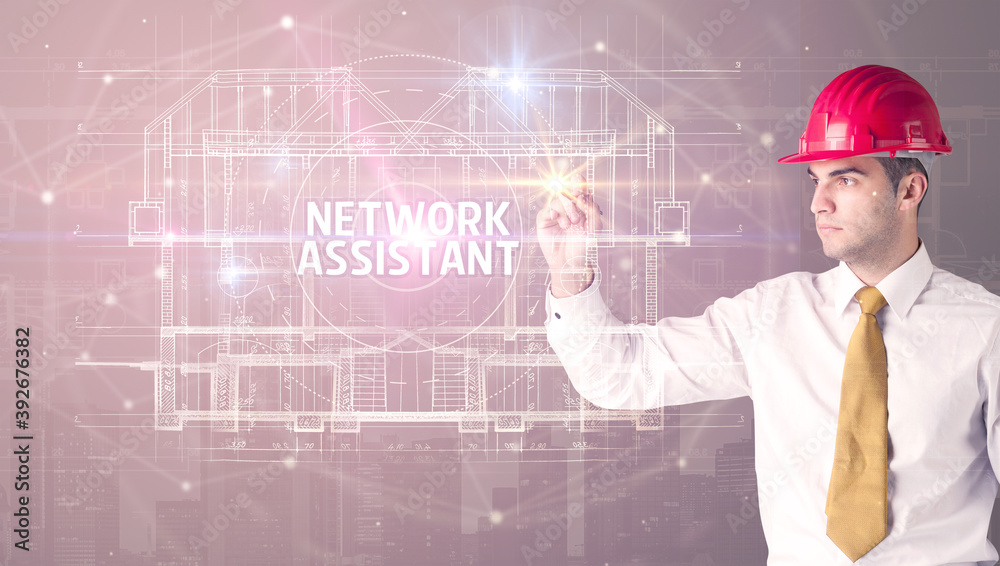 Handsome architect with helmet drawing NETWORK ASSISTANT inscription, new technology concept Handsome architect with helmet drawing NETWORK ASSISTANT inscription, new technology concept