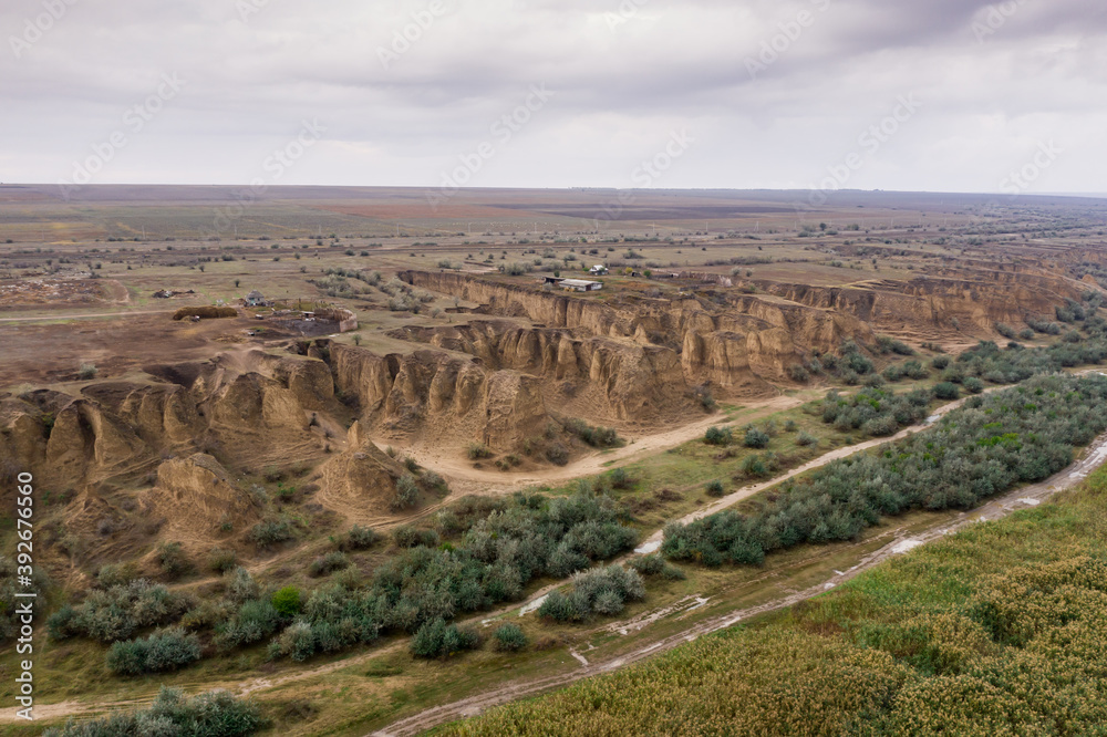 Aerial top view of countryside road dividing grinery and sand dunes. Texture of green plants view from above.