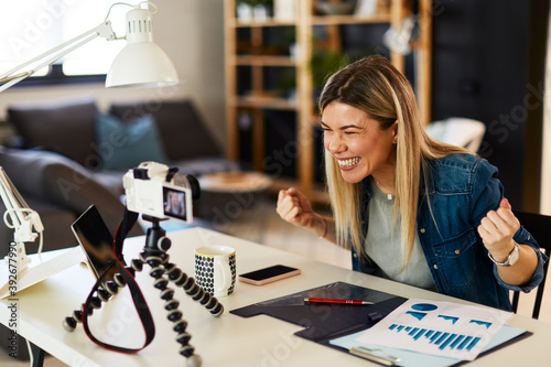 Young business woman recording video for her vlog at home. photo