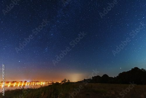 A magical starry night on the river by the Milky Way and a comet in the sky