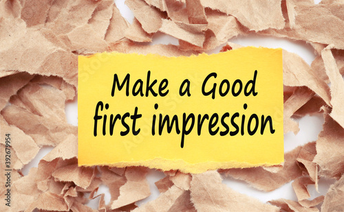 MAKE AGOOD IRST IMPRESSION, TEXT ON YELLOW PAPER WITH TORN CRAFT PAPER BACKGROUND photo