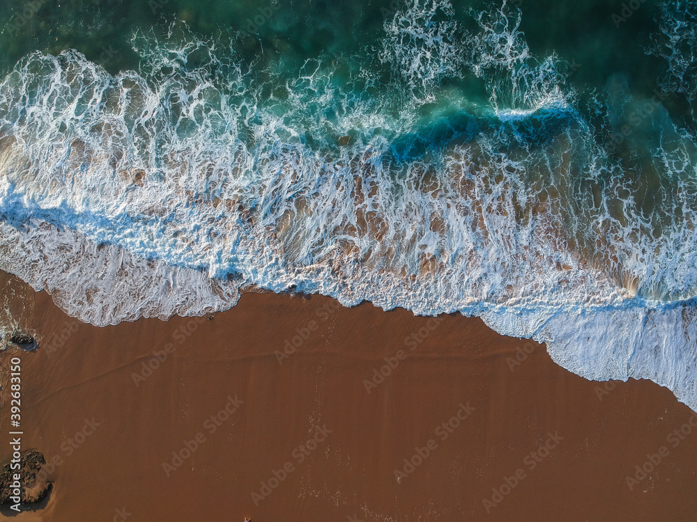 Aerial view of sea waves and sandy beach