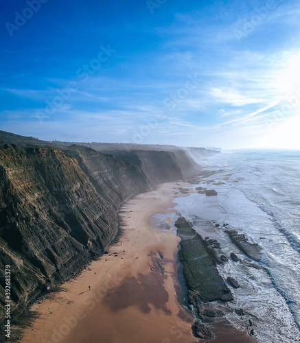 Aerial view of waves on a beautiful sandy ocean beach and cliff. Panorama atlantic coastline.