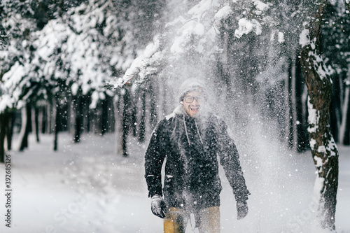 Happy smiling man under tha falling snow