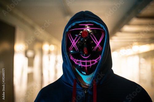 neon masked criminal on the dark. Selective focus photo