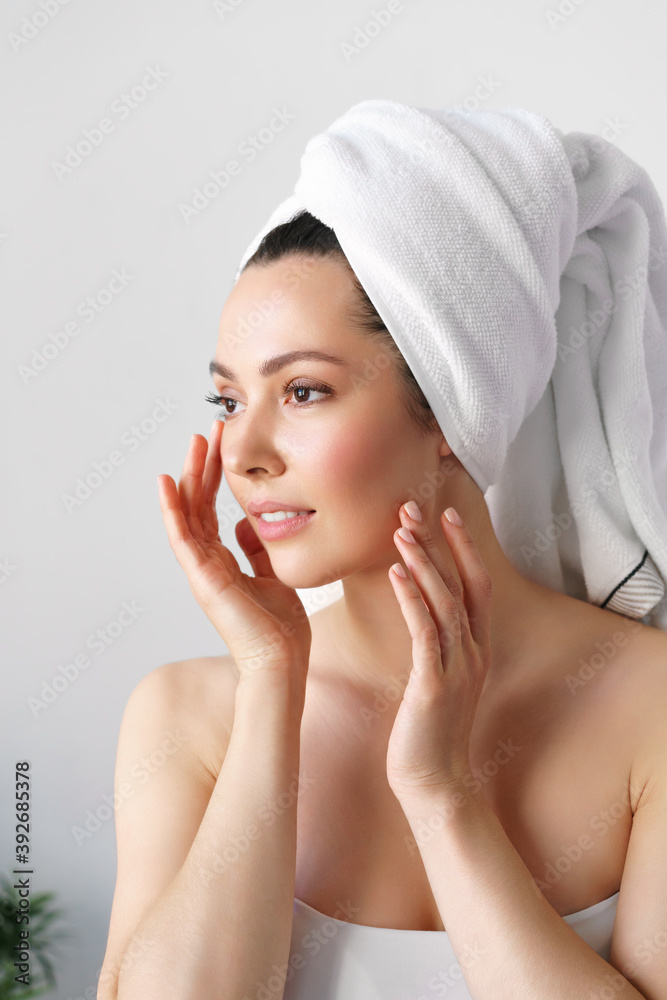 A natural woman with good skin holds her cheeks and looks in the mirror. SPA, cosmetology, beauty A natural woman with good skin holds her cheeks and looks in the mirror. SPA, cosmetology, beauty