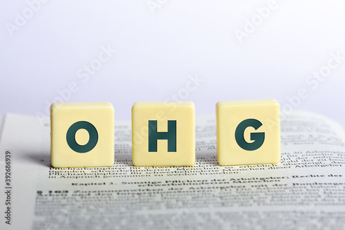 OHG in Buchstaben auf einem aufgeschlagenen Buch