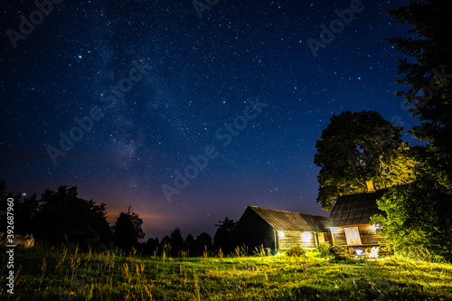 Overhead milky way with stars in clear summer night. Old barn house. Country side. © nikwaller