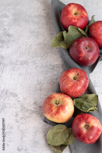 Ripe red apples on grey background, space for text