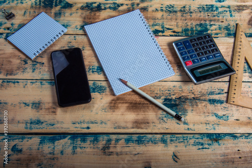 Top view of accountant desk with calculator, smart phone and pen