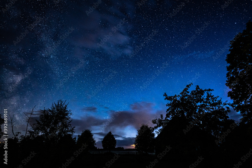 Fototapeta premium Overhead milky way with stars in clear summer night. Old barn house. Country side.