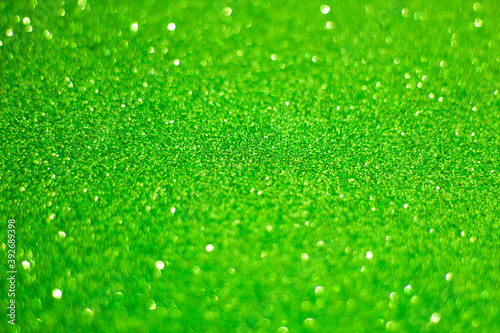 Abstract Christmas or Easter celebration background, green glitter, selective focus