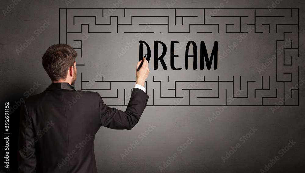 businessman drawing maze with DREAM inscription, business education concept