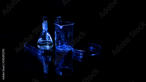 Different laboratory glassware with water and empty with reflection isolated on black