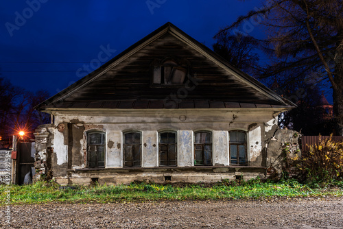 Old abandoned rural stone house at night.
