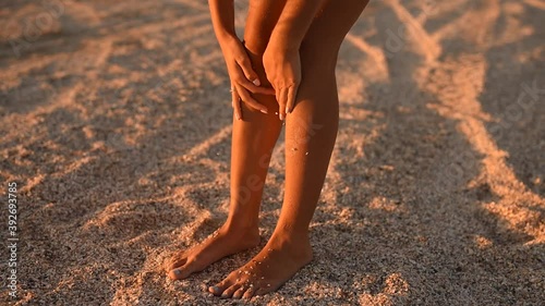young woman clean tanned legs. skinny tanned female legs covered with seashells and sea stones on the tropical ocean shore. slow motion. High quality FullHD footage. 