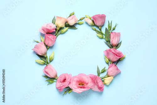 Frame of beautiful Eustoma flowers on light blue background, flat lay. Space for text