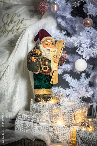 Santa Claus with skis and a card in his hands